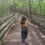 Girl standing on a bridge with arms out